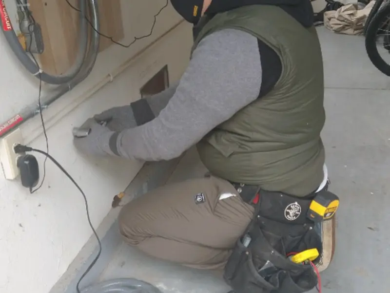 Electrician performing outlet wiring in a Echols County garage